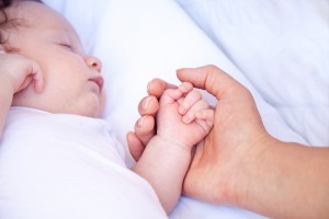 Madre che tiene per mano il bambino che dorme